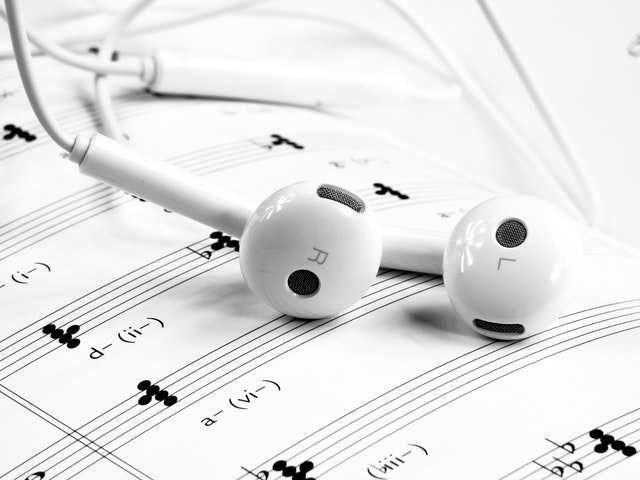 apple airpods sitting on music notes